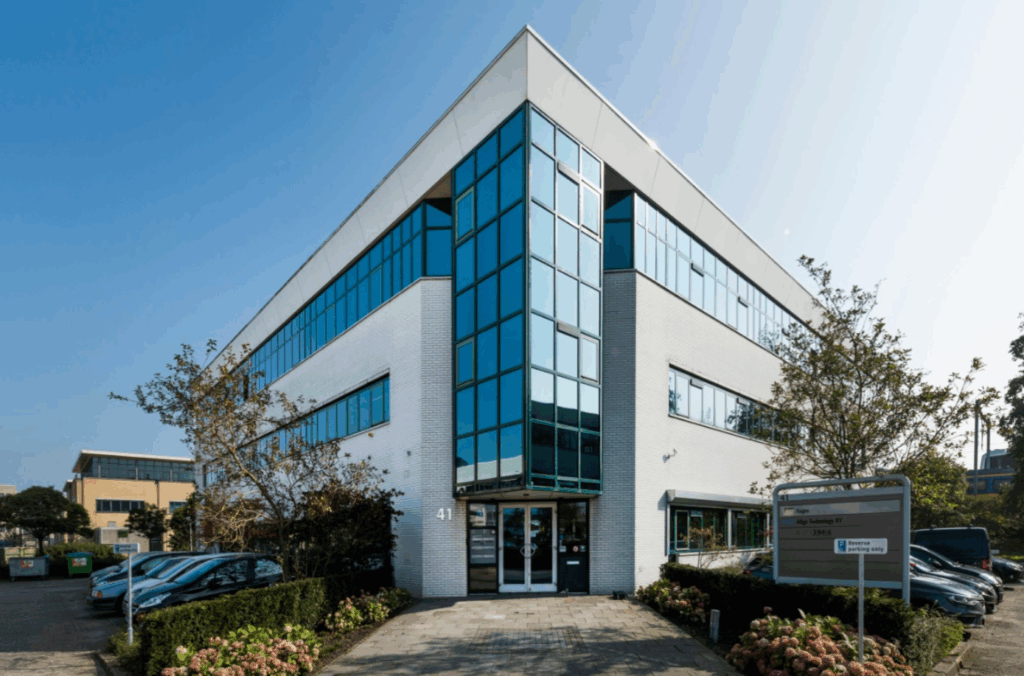 Modern office building with large glass windows and a visible sign for Edge Technology BV at the entrance.